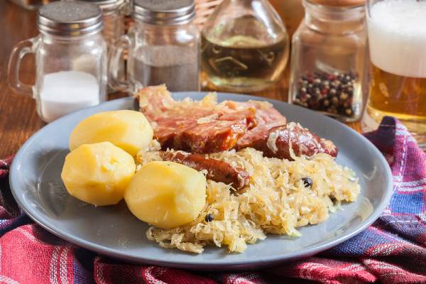 Assiette de choucroute avec du chou, des pommes de terre, de la saucisse et du lard 
