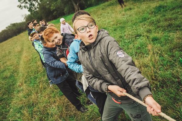 enfants jouant au tir à la corde en colonie de vacances 