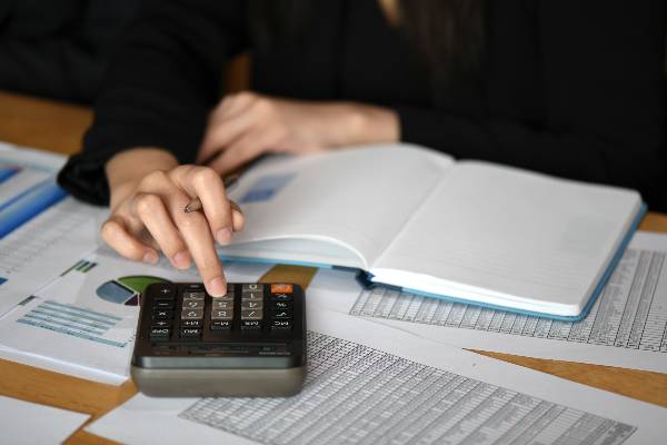 female makes calculations on a calculator in offic 2021 08 26 17 53 49 utc