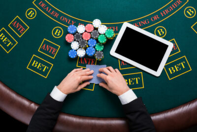 casino, online gambling, technology and people concept close up of poker player with playing cards