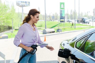 femme contente du prix des carburants