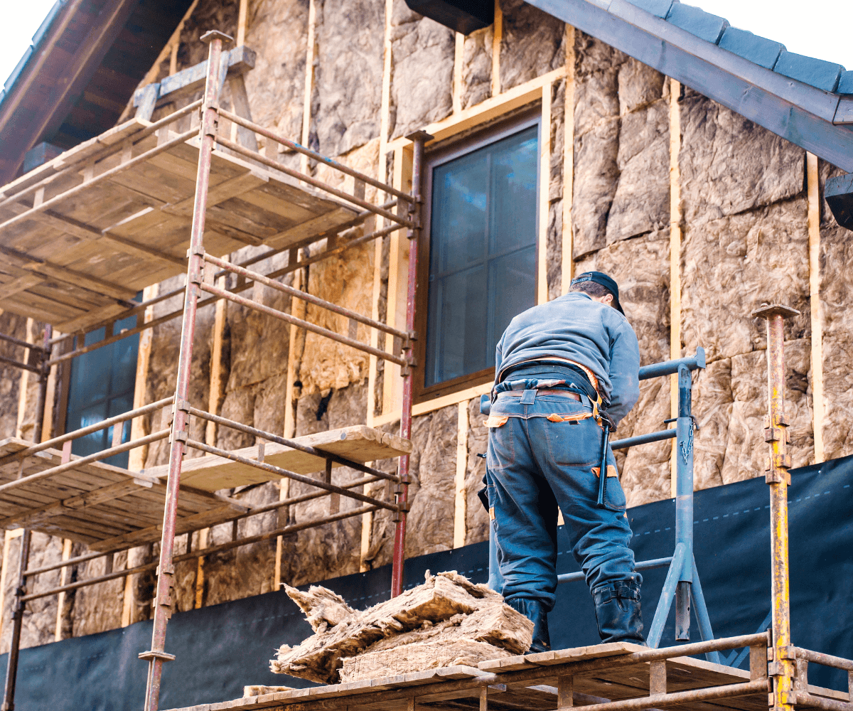 Un homme effectue des travaux de rénovation d'une passoire thermique.