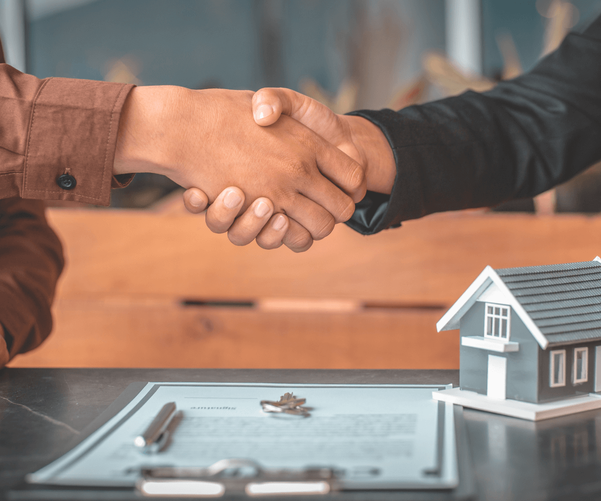 Un agent et son client concluent une vente immobilière. 
