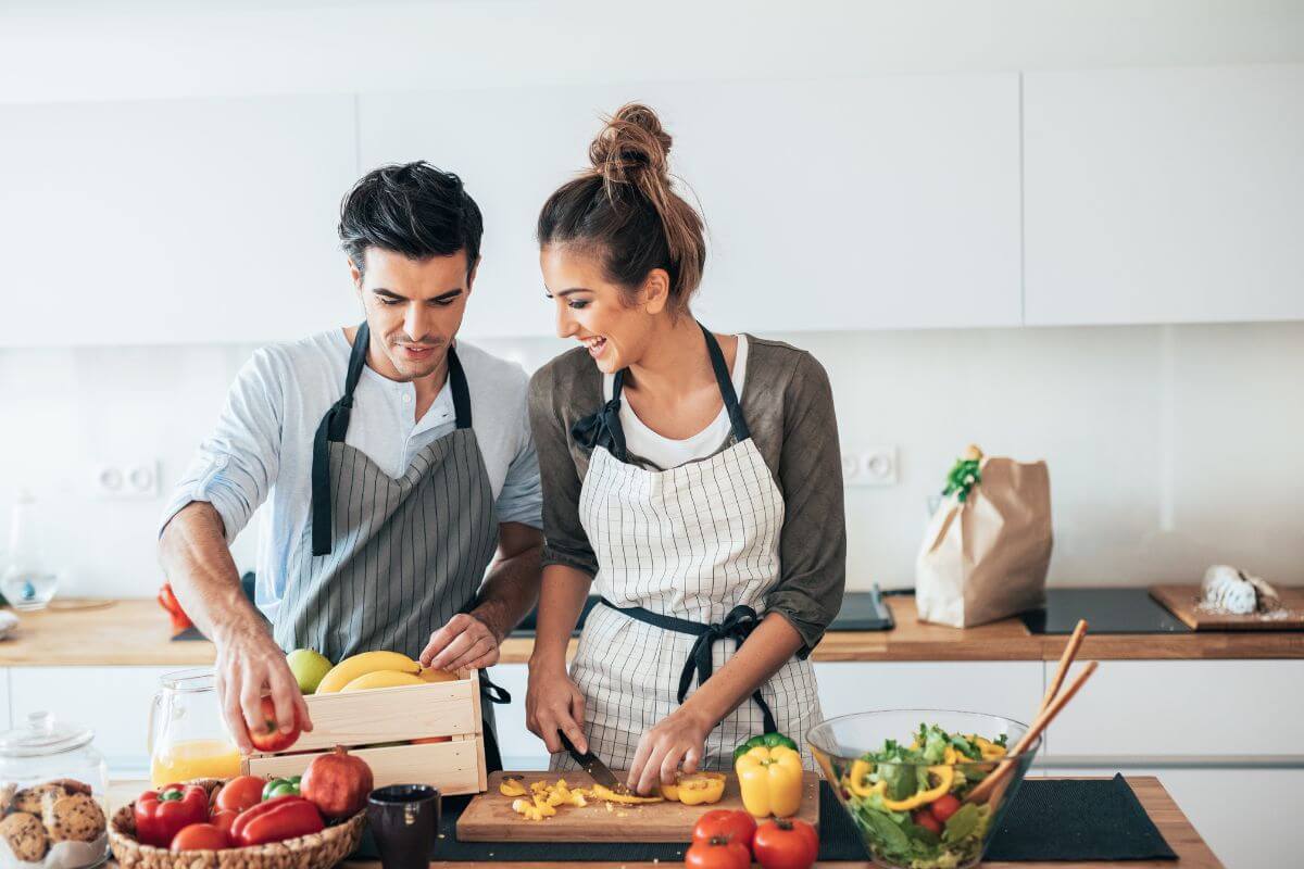 Un couple fait la cuisine ensemble comme activité de loisir.